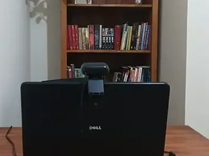 Detalhe da mesa de trabalho da sala online do NUAMCE, com tomada e luminária