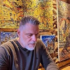 Retrato do psicanalista Daniel Gostautas em seu consultório, com expressão reflexiva e ambiente decorado ao fundo.