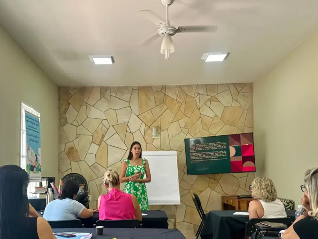 Palestrante conduzindo workshop para grupo de terapeutas em sala climatizada e equipada com TV e flip chart, disponível para locação em Campinas.